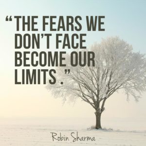 A picture of a tree with a pale blue background with the words "The fears we don't face become our limits"