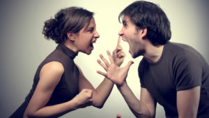 A man and a woman shouting at each other and raising hands and clenching fists showing a bad relationships